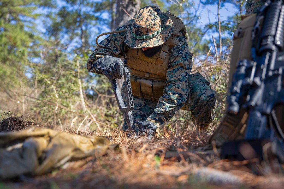 Lance Cpl. Corey Camphouse, a field radio operator for Battlespace Surveillance Company, digs a spot for a ground sensor during a ground sensor emplacement training exercise on Camp Shelby, Miss., Feb. 19, 2021. This training develops and refines platoon and section patrolling and increases proficiency in ground sensor operations. (U.S. Marine Corps photo by Lance Cpl. Mitchell Collyer)