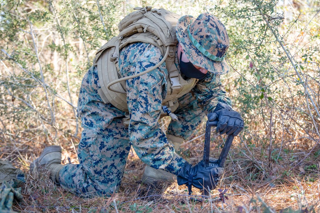 Lance Cpl. Corey Camphouse, a field radio operator for Battlespace Surveillance Company, digs a spot for a ground sensor during a reconnaissance and surveillance field exercise on Camp Shelby, Miss., Feb. 19, 2021. This training develops and refines platoon and section patrolling and increases proficiency in ground sensor operations. (U.S. Marine Corps photo by Lance Cpl. Mitchell Collyer)