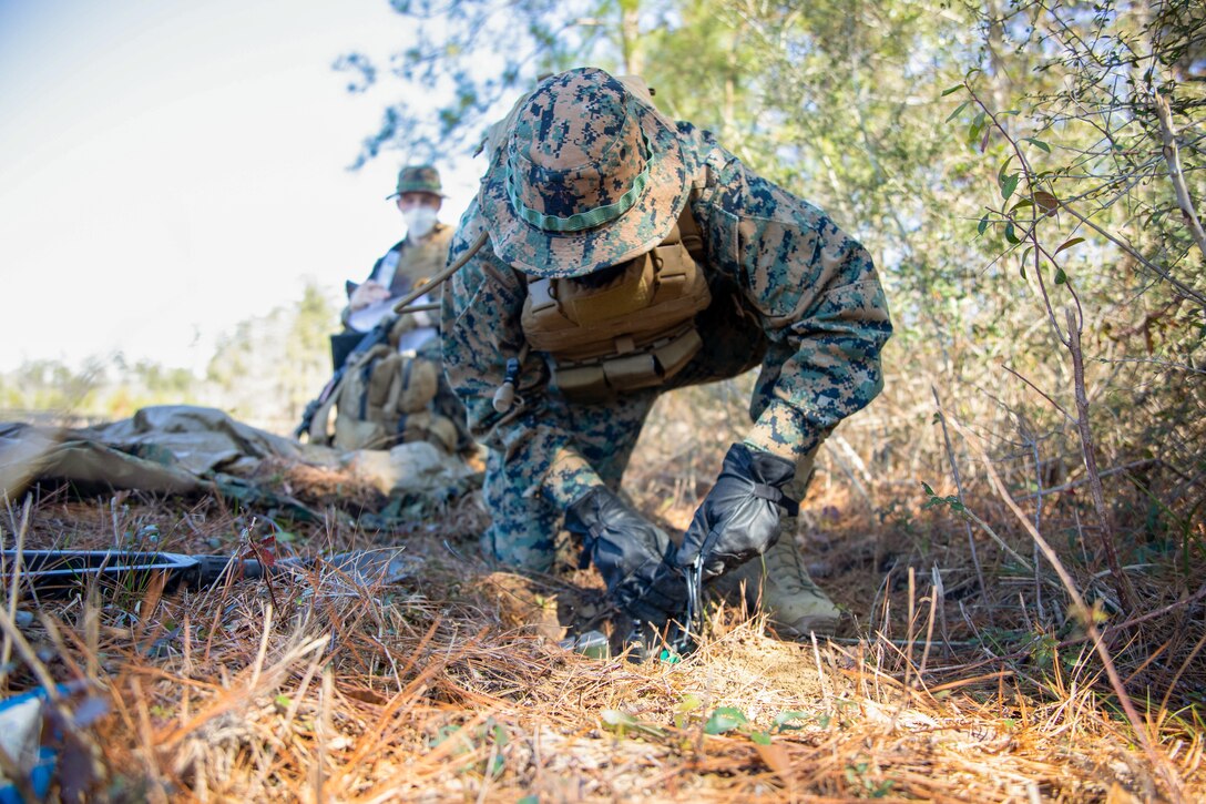 Lance Cpl. Corey Camphouse, a field radio operator for Battlespace Surveillance Company, conceals a ground sensor during a reconnaissance and surveillance field exercise on Camp Shelby, Miss., Feb. 19, 2021. This training develops and refines platoon and section patrolling and increases proficiency in ground sensor operations.  (U.S. Marine Corps photo by Lance Cpl. Mitchell Collyer)