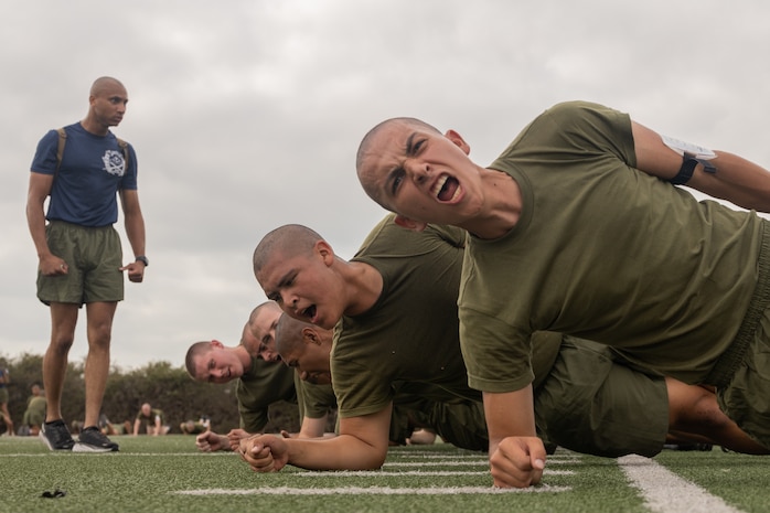 U.S. Marine Corps recruits with Kilo Company, 3rd Recruit Training Battalion, execute side planks during a physical training session at Marine Corps Recruit Depot San Diego, Sept. 19, 2023. Physical training challenges recruits to strengthen themselves physically and mentally. (U.S. Marine Corps photo by Lance Cpl. Janell B. Alvarez)