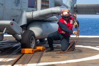 BM3 Jermaine Washington removes chains from a helicopter during flight operations aboard USS Antietam (CG 54) in the Philippine Sea.