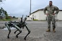 Master Sgt. Garcia smiles at robot dog