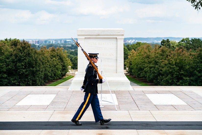 A uniformed service member holds a weapon.