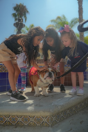 U.S. Marine Corps Pvt. Bruno, the mascot of Marine Corps Recruit Depot San Diego, Western Recruiting Region, receives head scratches from kids during Family Day at MCRD San Diego, Sept. 7, 2023. The mascots job is to boost morale, participate in outreach work, and attend events and ceremonies. (U.S. Marine Corps photo by Lance Cpl. Francisco Angel)