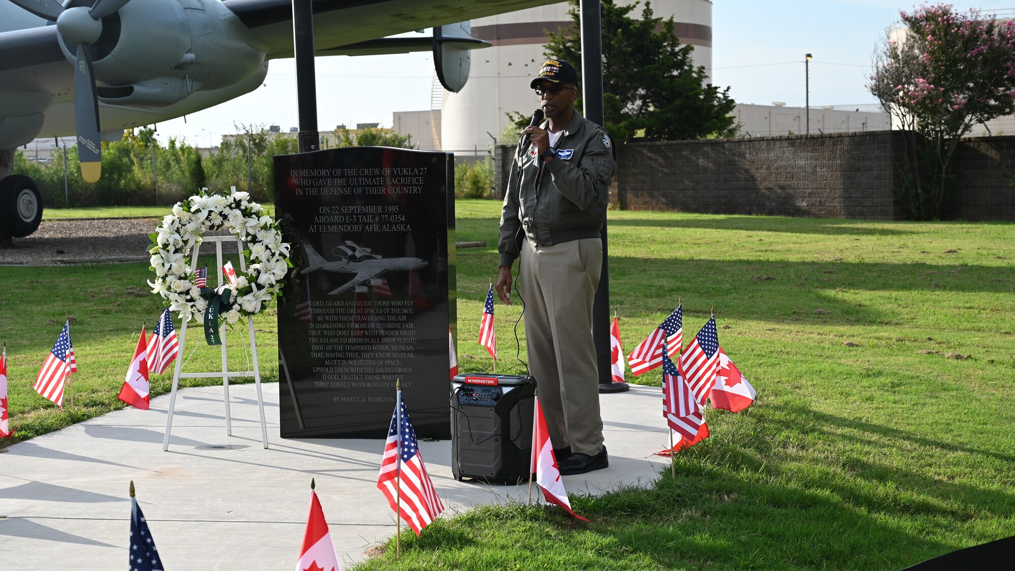 speaker stands in front of memorial