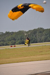 a parachute team prepares to land