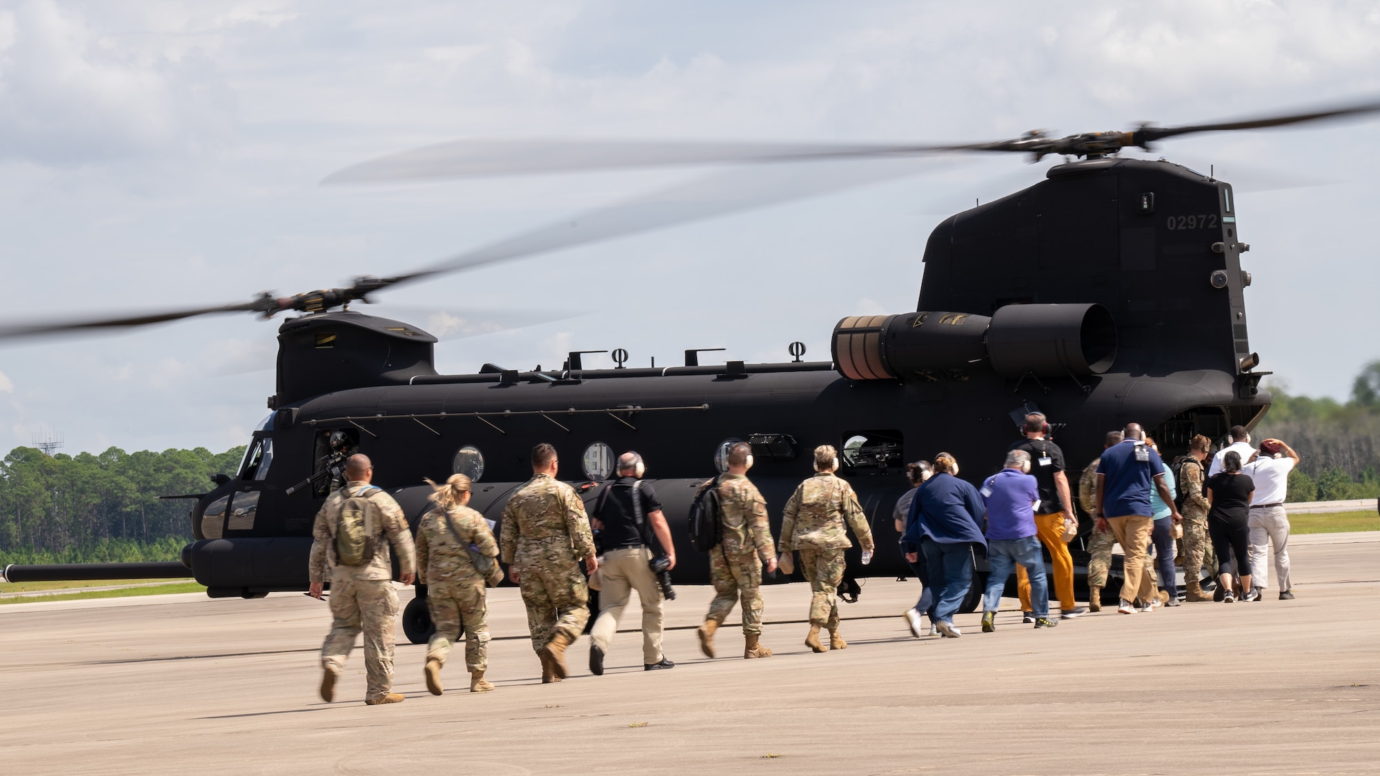 Participants of the 94th Joint Civilian Orientation Conference make their way to a MH-47G Chinook.