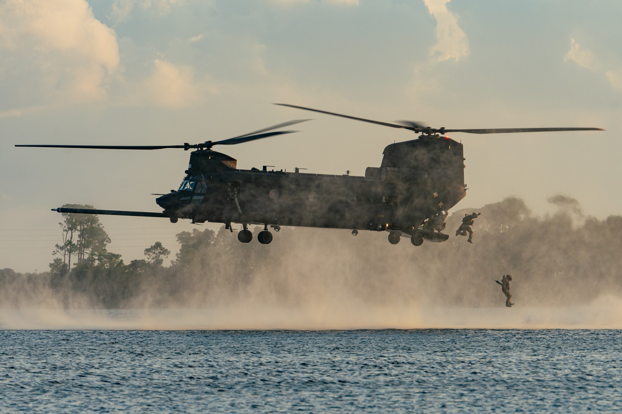 U.S. Air Force Airmen jump from a U.S. Army MH-47G Chinook helicopter assigned to the 160th Special Operations Aviation Regiment during the 94th Joint Civilian Orientation Conference at Hurlburt Field, Florida, Sept. 20, 2023