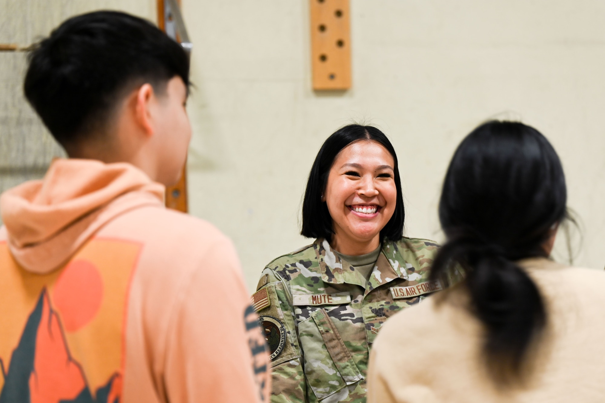 woman in uniform smiles at students