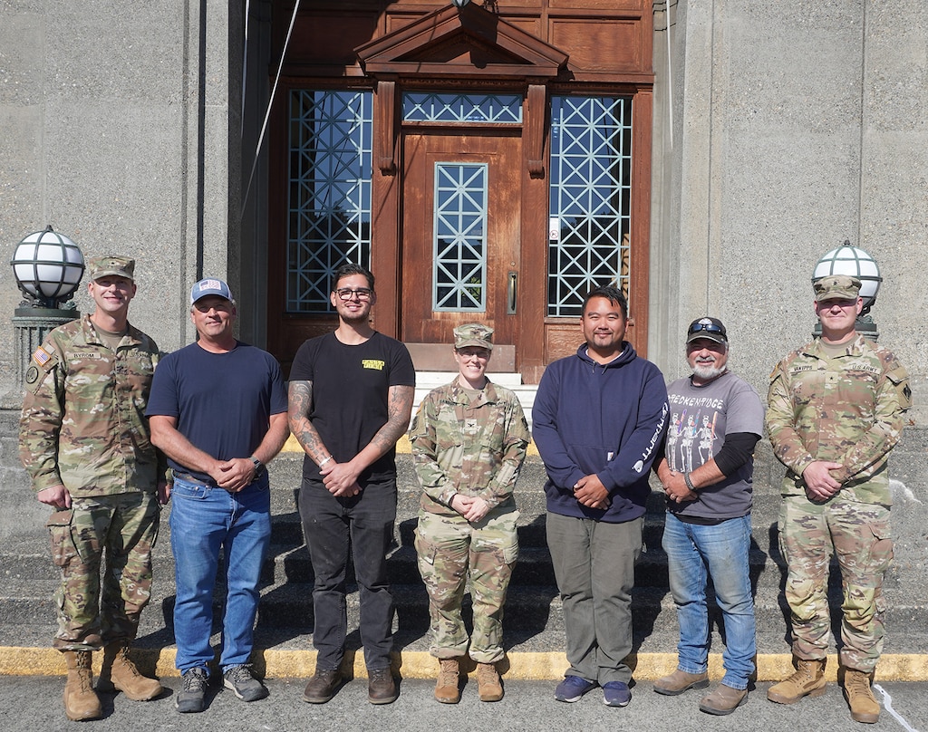 Group photo of Army officers and civilians standing in front of the Administration building of the Lake Washington Ship Canal and Hiram M. Chittenden Locks, Seattle, Washington.