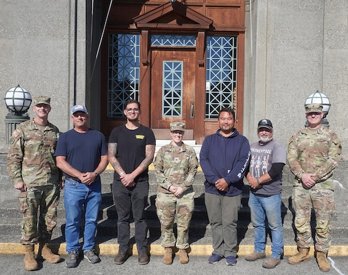 Group photo of Army officers and civilians standing in front of the Administration building of the Lake Washington Ship Canal and Hiram M. Chittenden Locks, Seattle, Washington.