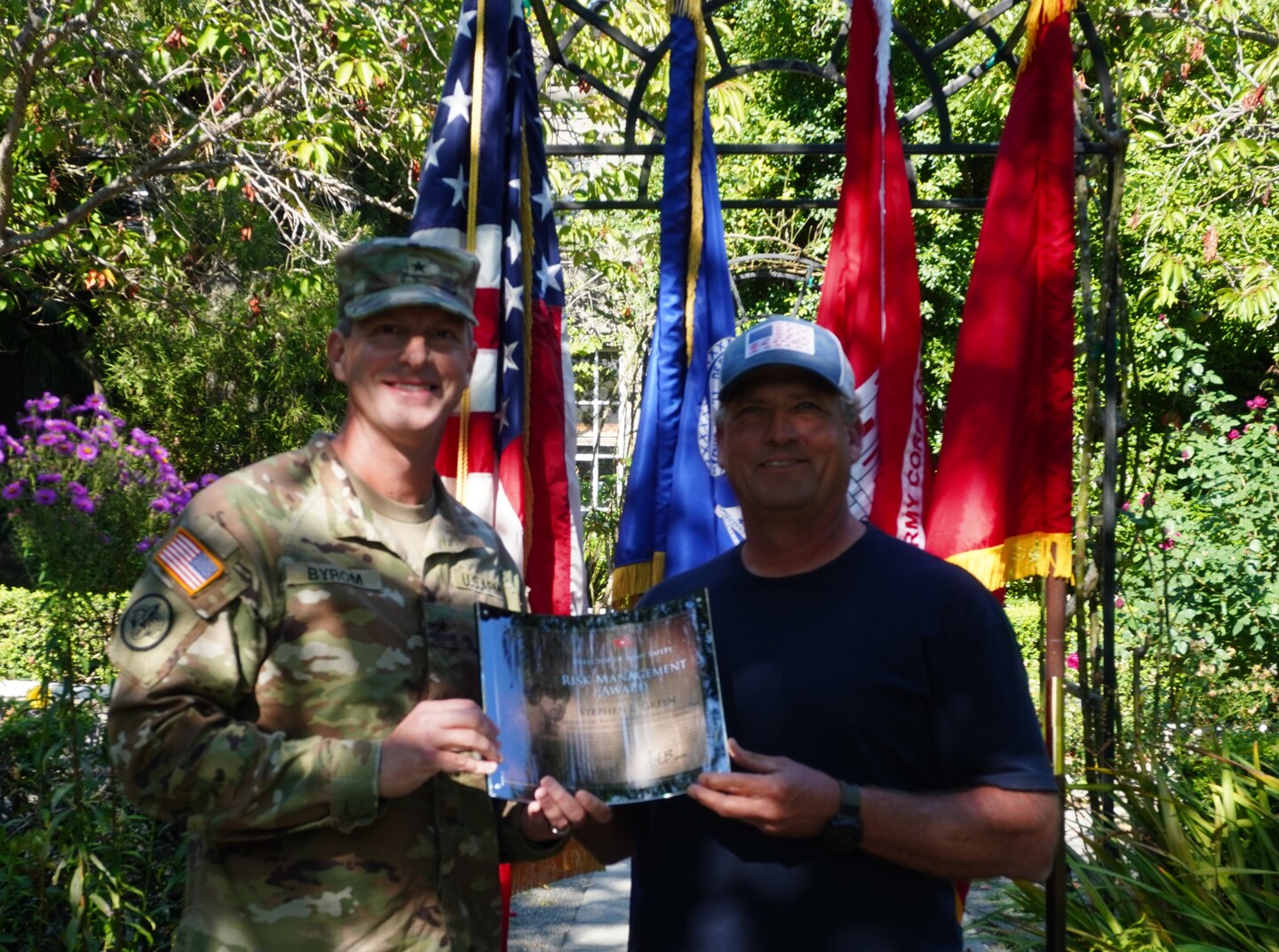An Army officer presents an award to a civilian in the rose garden of the Lake Washington Ship Canal and Hiram M. Chittenden Locks, Seattle, Washington