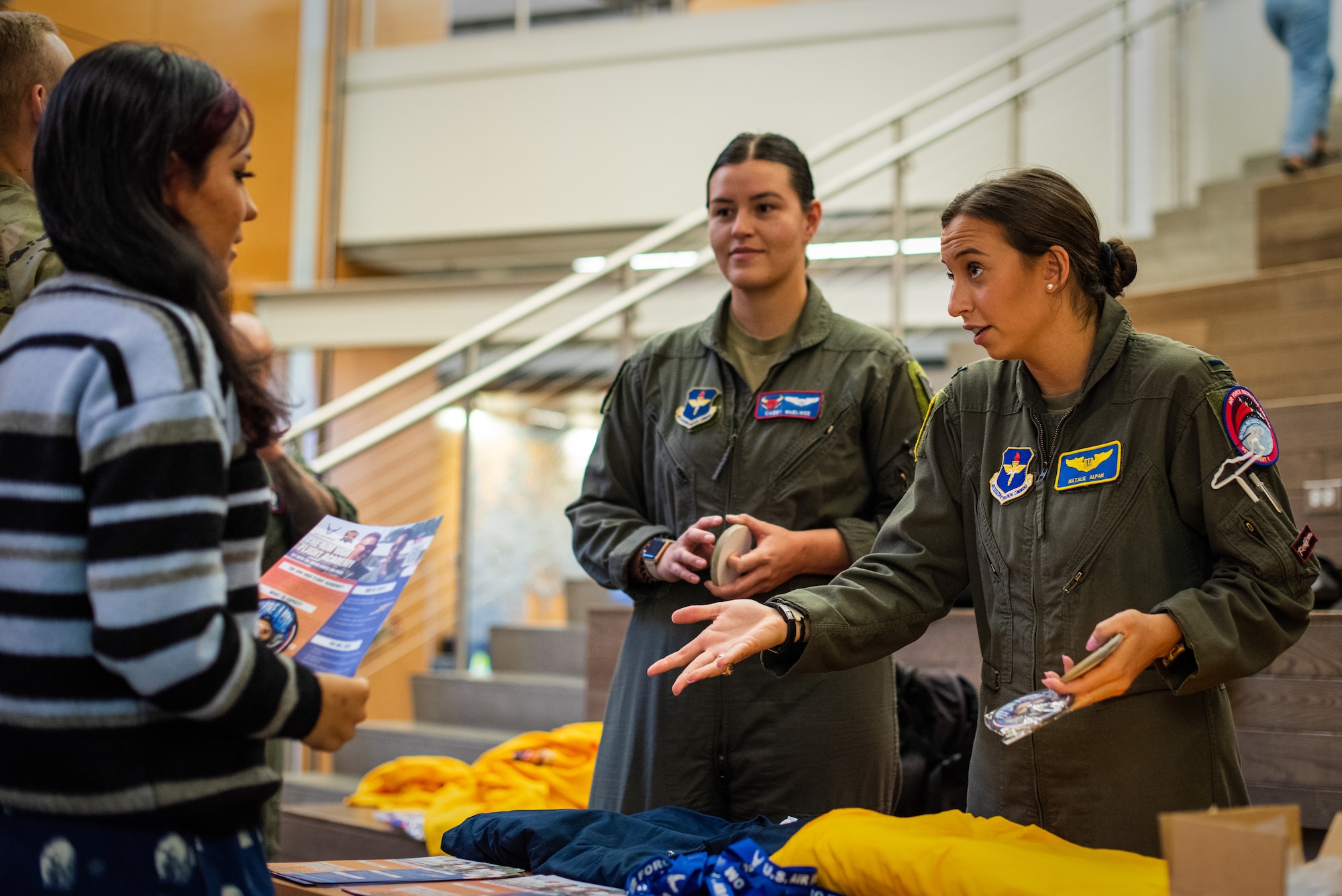 (From right) U.S. Air Force 1st Lt. Natalie Alpan, an MQ-9 Reaper pilot assigned to the 89th Attack Squadron at Creech Air Force Base, Nevada, and U.S. Air Force Capt. Cassandra McElwee, T-38C Talon instructor pilot assigned to the 87th Flying Training Squadron, Laughlin Air Force Base, Texas, speak to a students about the Aim High Flight Academy during a recruiting visit to Kodiak High School, in Kodiak, Alaska, Sept. 6, 2023.