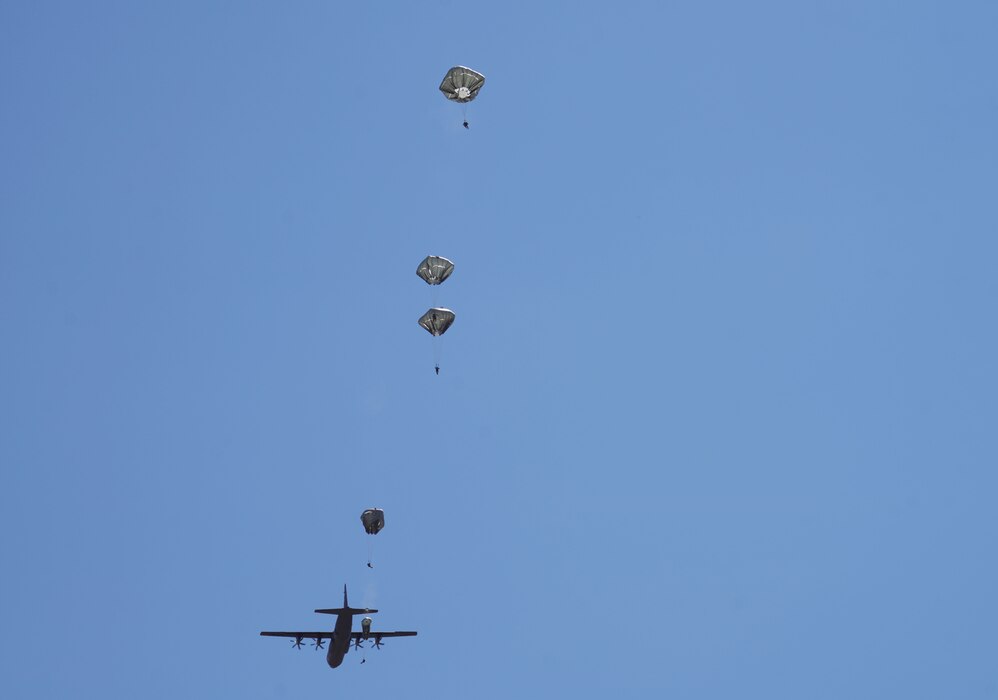 A photo of U.S. Army paratroopers jumping from the back of a C-130J aircraft.