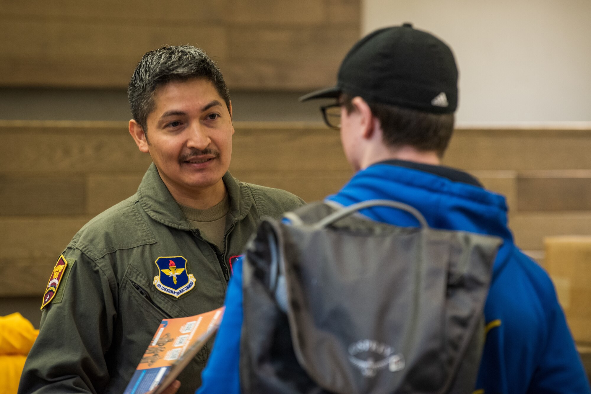 U.S. Air Force Tech. Sgt. Jacob Arellano, outreach recruiter assigned to Air Force Recruiting Service Detachment 1, Joint Base San Antonio-Randolph, Texas, speaks with a student about the Aim High Flight Academy during a recruiting visit to Kodiak High School, in Kodiak, Alaska, Sept. 6, 2023.