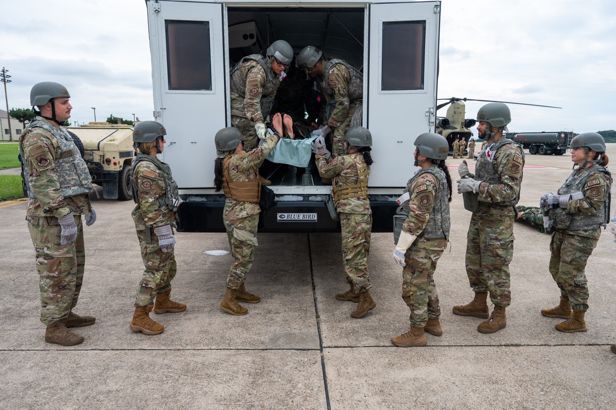 A group of Airmen from the 8th Medical Group remove a medical training mannequin from a vehicle while participating in a joint medical evacuation training