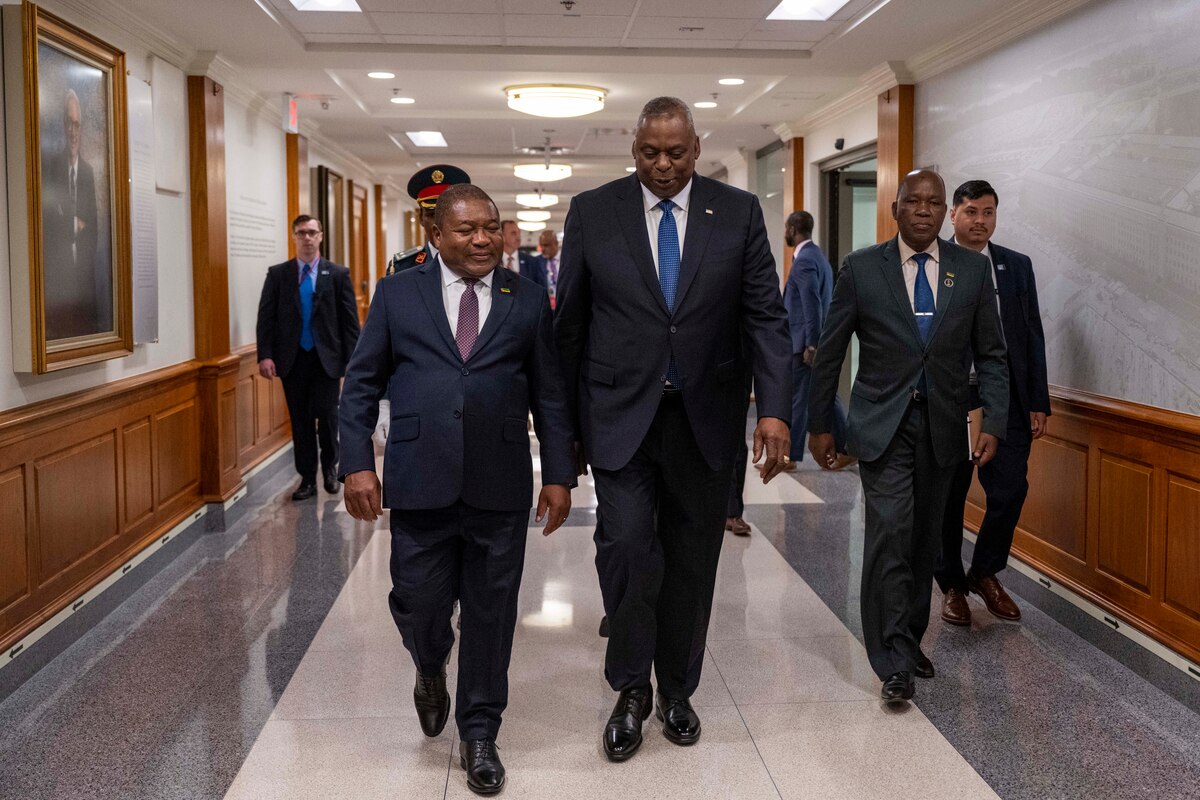 A group of people walk down a hallway.