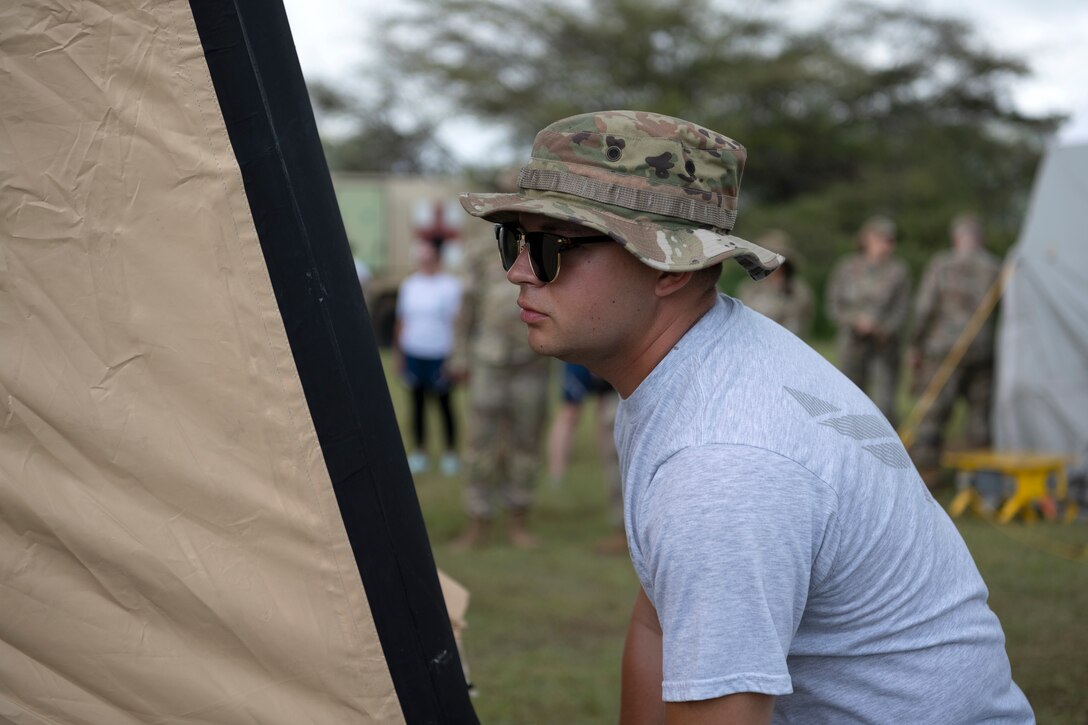 A U.S. Airman assigned to the Kentucky Air National Guard's 123rd Medical Group, Detachment 1, lifts an inflatable tent during a collective training exercise at Camp Santiago Joint Training Center, Salinas, Puerto Rico, Aug. 10, 2023. The exercise allowed service members assigned to the 156th Medical Group, 123rd Medical Group and the Puerto Rico Army National Guard to exchange knowledge and implement the National Guard CBRN Response Enterprise Information Management System, which assists with accelerating data collection from search and extraction teams in emergency events. (U.S. Air National Guard photo by Master Sgt. Rafael D. Rosa)