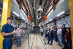 Naval Surface Warfare Center, Port Hueneme Division (NSWC PHD)’s White Sands Detachment Site Director Abie Parra (left) leads the NSWC PHD executive steering group on a tour of a facility that houses a launch rail (above center) at White Sands Missile Range on May 24. Before launching a sounding rocket, the whole building rolls away on tracks. (U.S. Navy photo by Eric Parsons/Released)