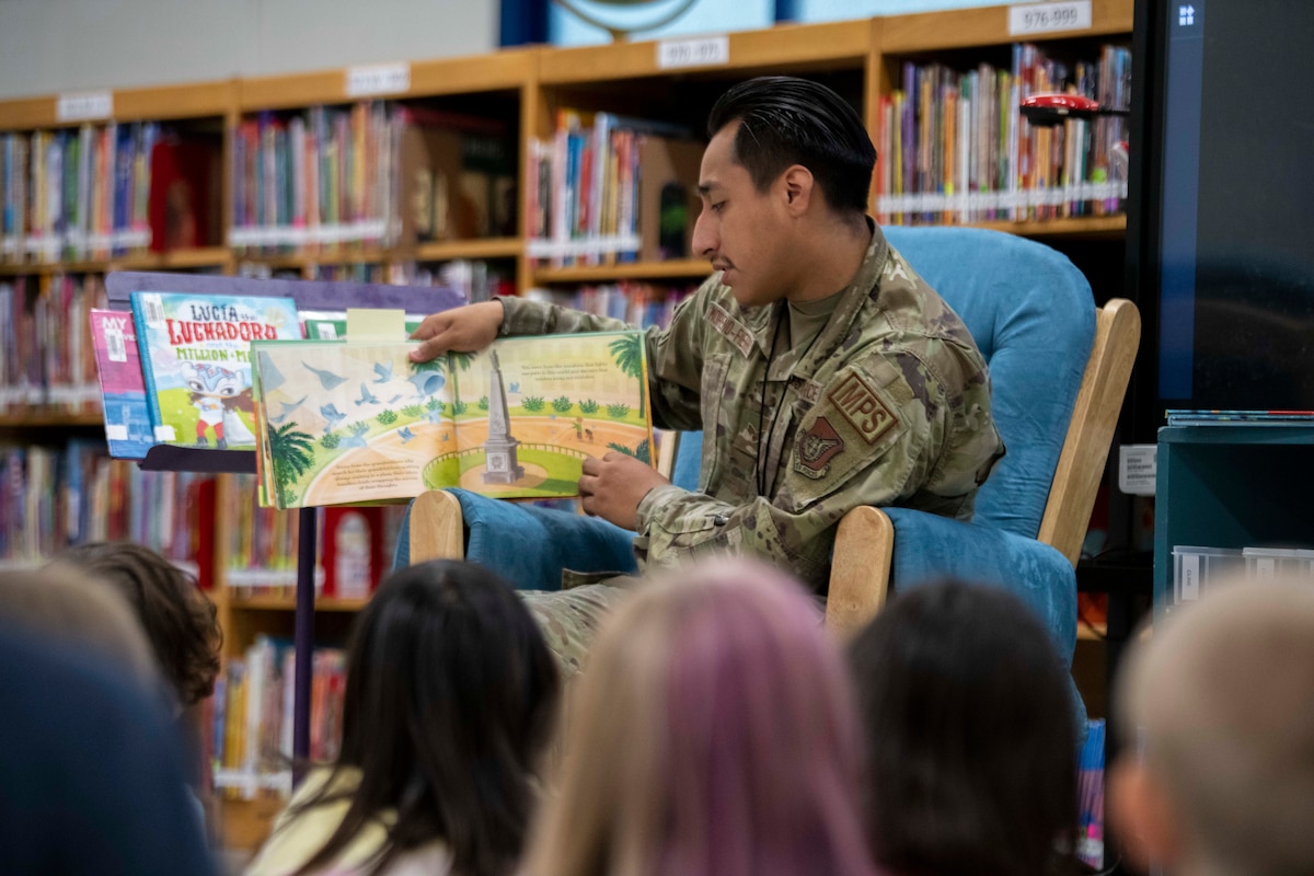 A military man reads to students.