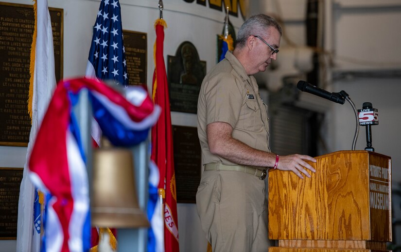 U.S. Navy Capt. Andrew Peterson, Joint Base Charleston deputy commander, delivers opening remarks during the Bells Across America ceremony aboard the decommissioned aircraft carrier USS Yorktown