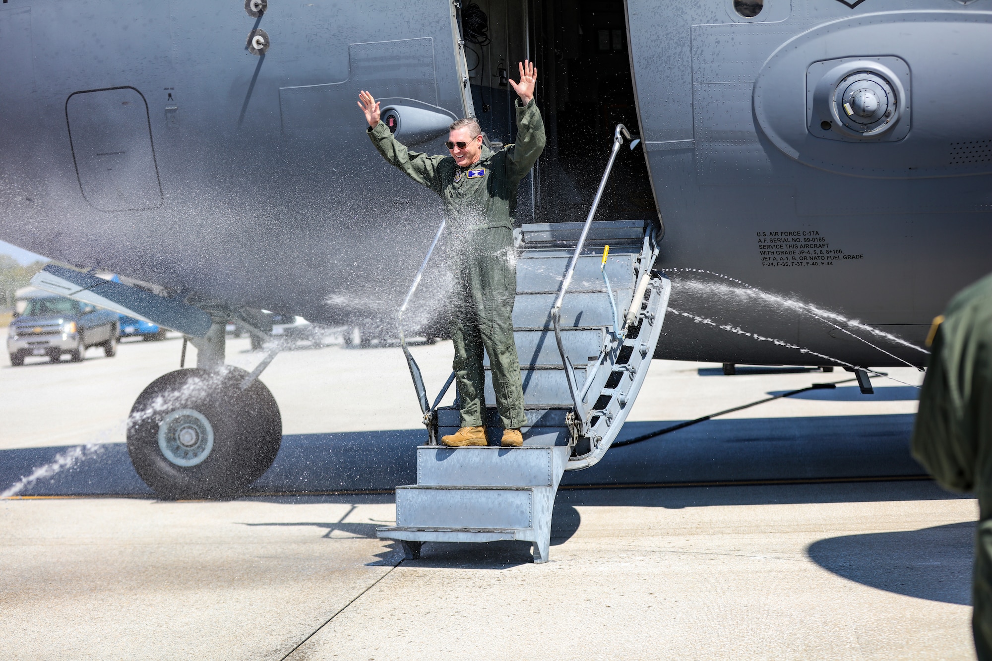 Col. Nathan Day, 445th Airlift Wing Deputy Commander, is hosed down by family and friends after landing at Wright-Patterson Air Force Base, Ohio for his final C-17 Globemaster III flight Sept. 22, 2023.