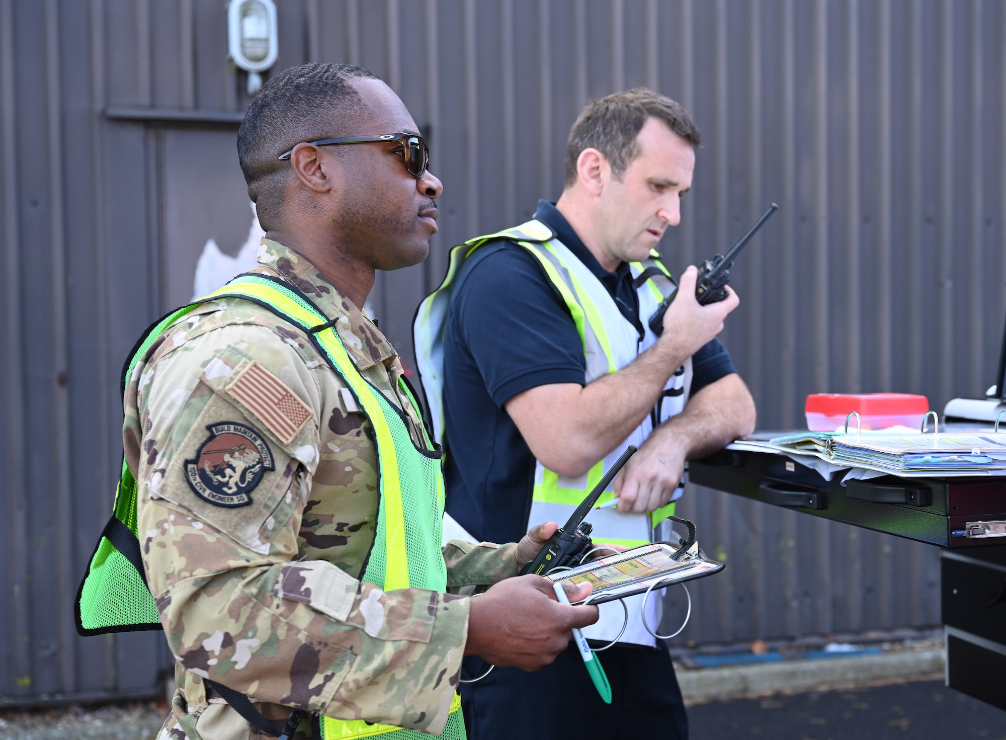 U.S. Air Force Tech. Sgt. Antwon Cole, left, 100th Civil Engineer Squadron Fire Department assistant chief of operations, and Andrew Armstrong, 100th CES Fire Department watch manager, run incident command duties during a natural disaster mass care exercise at Royal Air Force Mildenhall, England, Sept. 21, 2023. The exercise allowed firefighters and 100th Security Forces Squadron defenders to practice performing essential operations during a simulated natural disaster incident. (U.S. Air Force photo by Karen Abeyasekere)