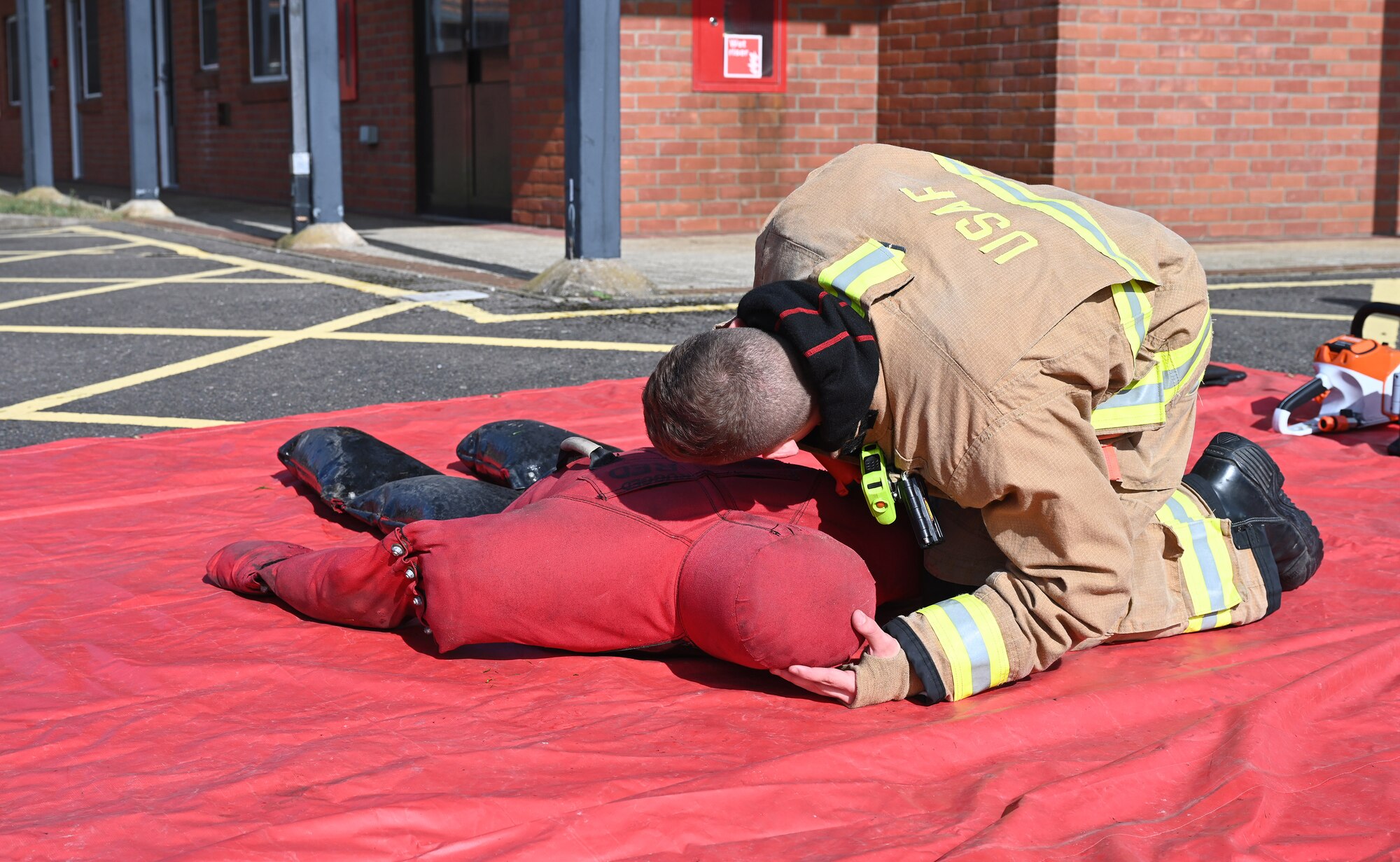 U.S. Air Force Airman 1st Class Jacob Meyer, 100th Civil Engineer Squadron Fire Department firefighter, checks for signs of breathing on a simulated casualty during a natural disaster mass care exercise at Royal Air Force Mildenhall, England, Sept. 21, 2023. The exercise allowed firefighters and 100th Security Forces Squadron defenders to practice performing essential operations during a simulated natural disaster incident. (U.S. Air Force photo by Karen Abeyasekere)
