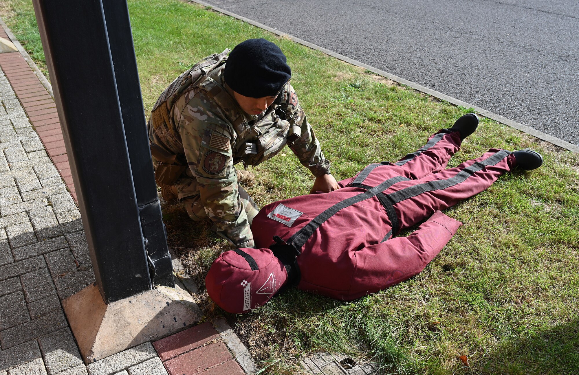 A U.S. Air Force 100th Security Forces Squadron defender checks a simulated patient for injuries during a natural disaster mass care exercise at Royal Air Force Mildenhall, England, Sept. 21, 2023. The exercise allowed defenders and 100th Civil Engineer Squadron firefighters to practice performing essential operations during a simulated natural disaster incident. (U.S. Air Force photo by Karen Abeyasekere)