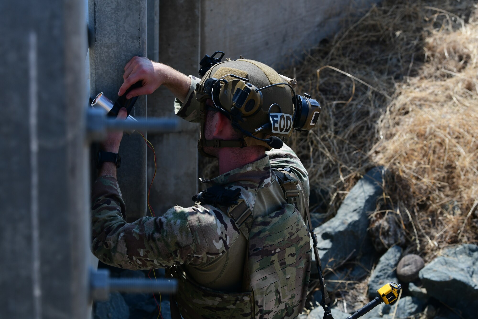 U.S. Air Force Senior Airman Zane Exner, 812th Civil Engineer Squadron explosive ordnance disposal (EOD) team lead, removes charges from a bridge during Exercise GOLDEN CRAB on Beale Air Force Base, California, Sept. 20, 2023.