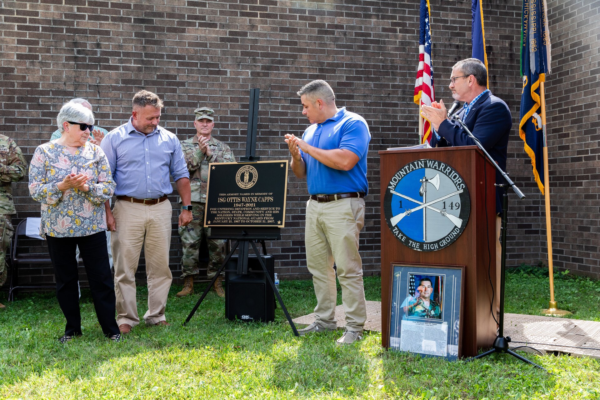 The wife of 1st Sgt. Ottis W. Capps, Sherry [left] and their two sons, Jeff and Jason, unveil the new bronze plaque at the Harlan National Guard Armory in Harlan, Kentucky on Sept. 21, 2023. The National Guard armory was named after 1st Sgt. Ottis W. Capps who served as the Alpha Company, 1-149th Infantry full-time support for over 30 years and was a cornerstone of the Harlan National Guard community during his career. (U.S. Army National Guard photo by Andy Dickson)