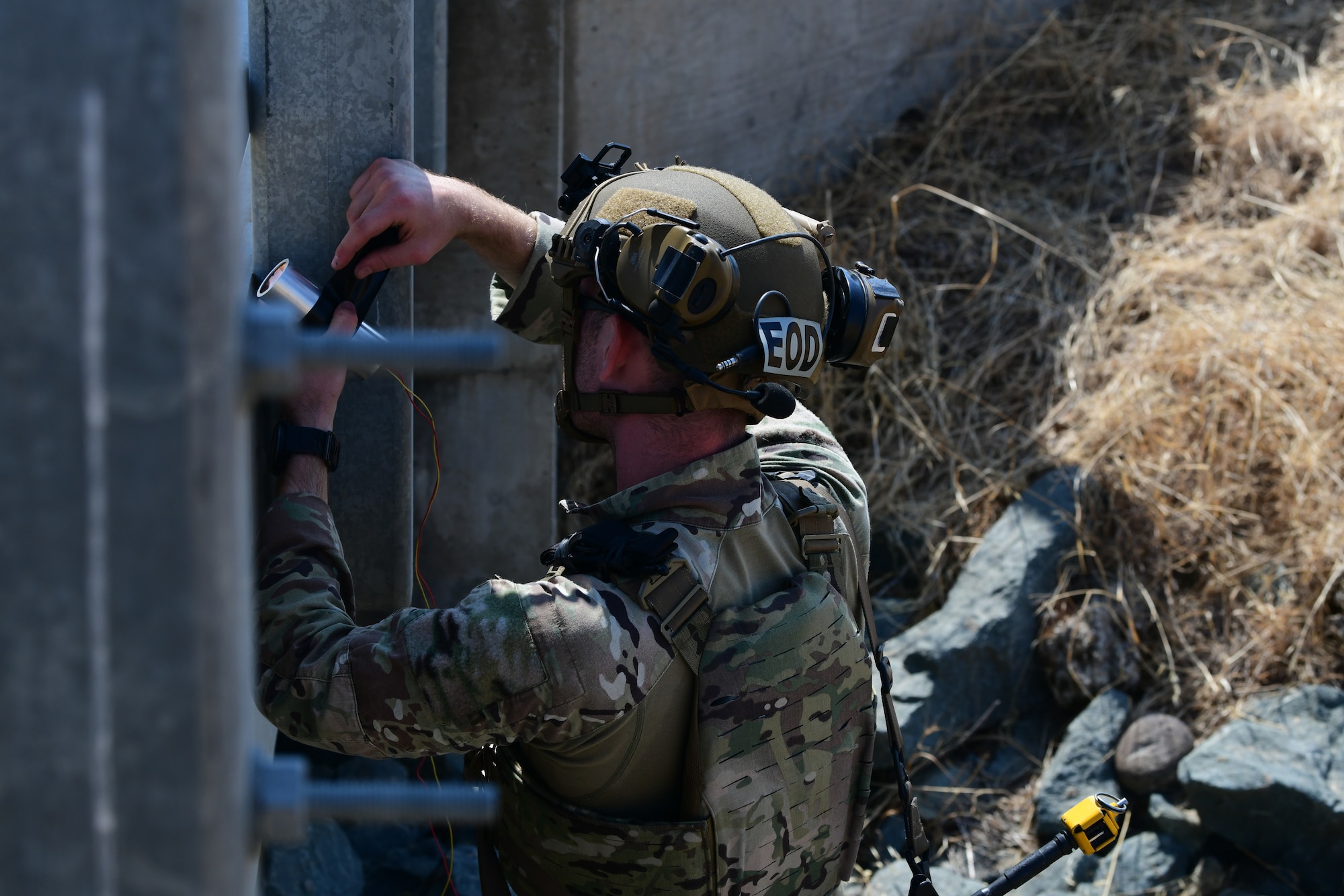 U.S. Air Force Senior Airman Zane Exner, 812th Civil Engineer Squadron explosive ordnance disposal (EOD) team lead, removes charges from a bridge during Exercise GOLDEN CRAB on Beale Air Force Base, California, Sept. 20, 2023.