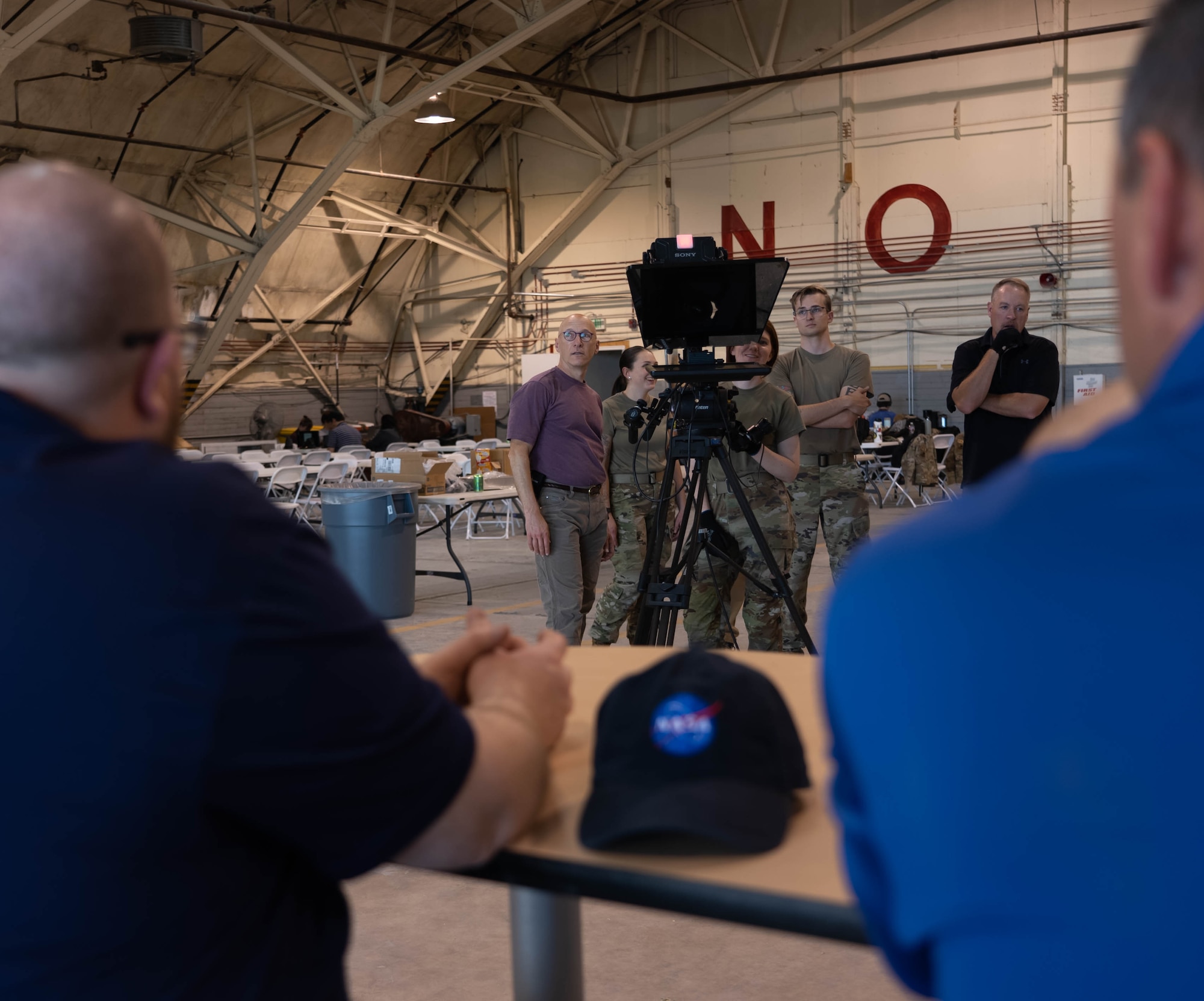 People working on a film set in an aircraft hangar