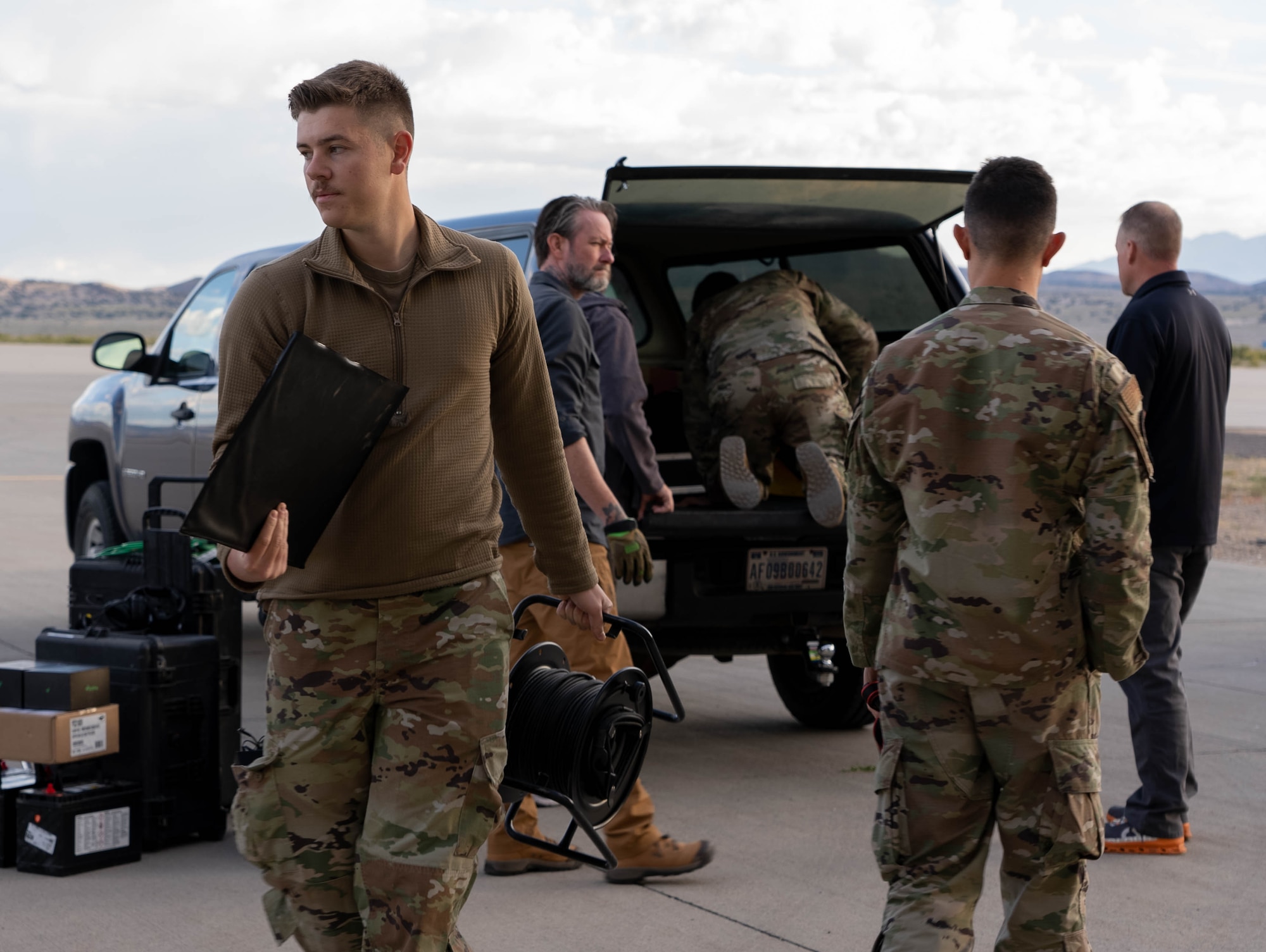 Airman unloading equipment from a pickup