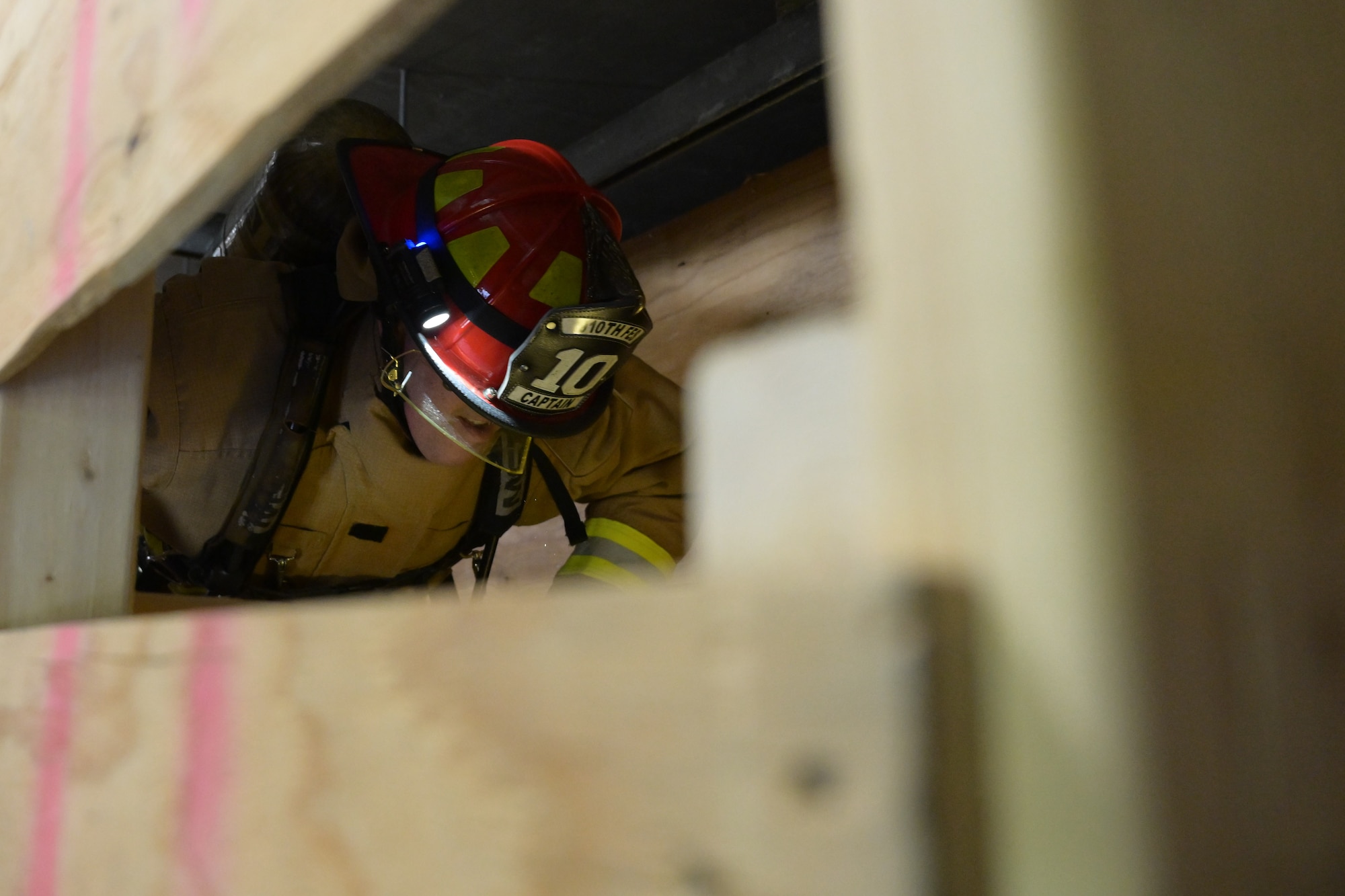 Col. Greg Meyer, 910th Mission Support Group commander crosses a series of boards designed to replicate an attic or elevated crawlspace during a run through a confined spaces obstacle course at Youngstown Air Reserve Station, Ohio, Sept. 21, 2023.