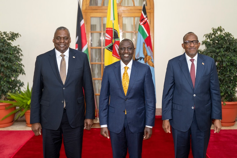 Three men pose for a photo.