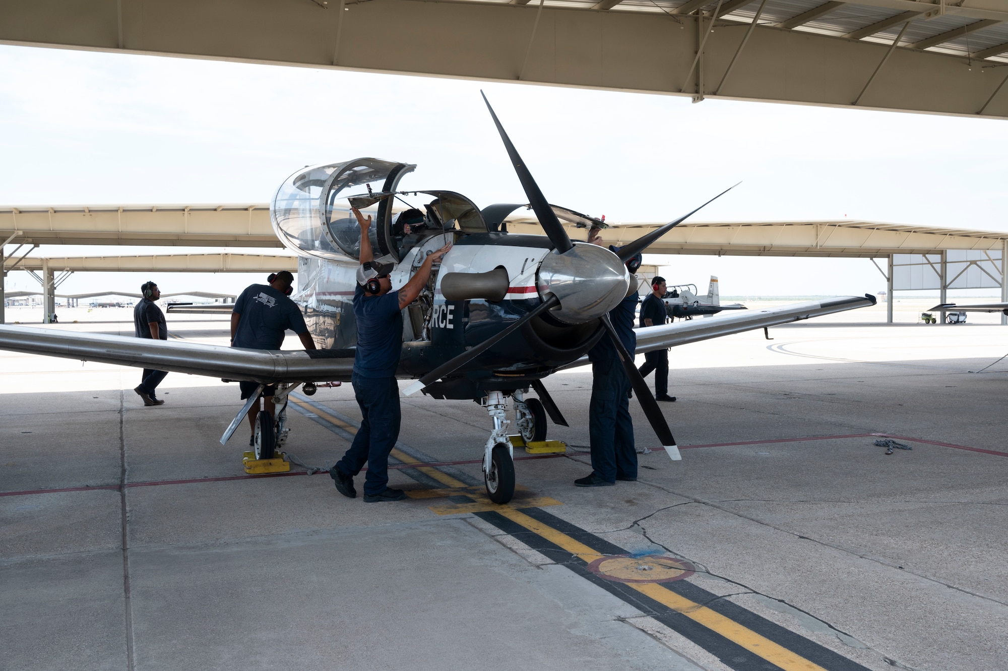 47th Maintenance Directorate aircraft attendants prepare a T-6A Texan II for inspection on the flight line at Laughlin Air Force Base, Texas, Sept. 11, 2023. In honor of Hispanic Heritage Month, these MXD workers were highlighted for their impact on Laughlin’s mission of producing the world’s best pilots. (U.S. Air Force photo by Airman 1st Class Kailee Reynolds)