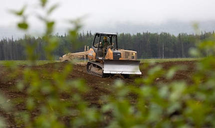 Alaska Army National Guard Sgt. David Kocur, a horizontal construction engineer assigned to the 910th Engineer Support Company, operates a grader to create a broad flat foundation on Joint Base Elmendorf-Richardson, Alaska, Aug. 8, 2023.