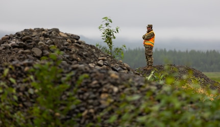Alaska Army National Guard Sgt. Brodie Smith, a horizontal construction engineer assigned to the 910th Engineer Support Company, oversees the operation of his squad as they operate heavy machinery in surveying land as a part of their annual training on Joint Base Elmendorf-Richardson, Alaska, Aug. 8, 2023.