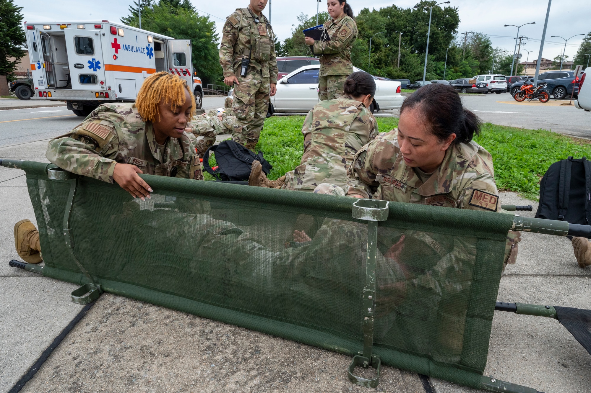U.S. Air Force Tech. Sgt. Zsane Wrice, flight medicine flight chief, and Staff Sgt. Maricris Belber, office manager, both from the 51st Operational Medical Readiness Squadron, load a simulated patient onto a stretcher during a mass casualty training event at Osan Air Base, Republic of Korea, Sept. 21, 2023. During the training event, 51st Medical Group personnel rushed to provide life-saving care, demonstrating commitment to readiness and preparedness. (U.S. Air Force photo by Senior Airman Aaron Edwards)