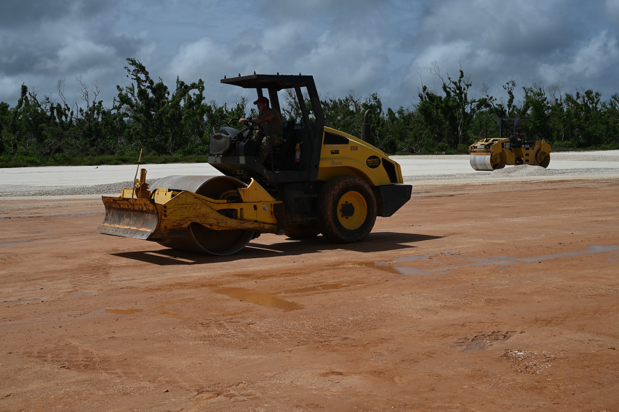 Airmen from the 513th ERHS use roller vehicles to compact base course material on the airfield.