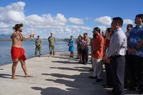Louis Santos, performs a traditional Hawaiian oli (chant) to bless the land, asking for protection and to foster good energy, during a Hawaiian blessing ceremony held at the water front of Pearl Harbor, as ceremony attendees look on.