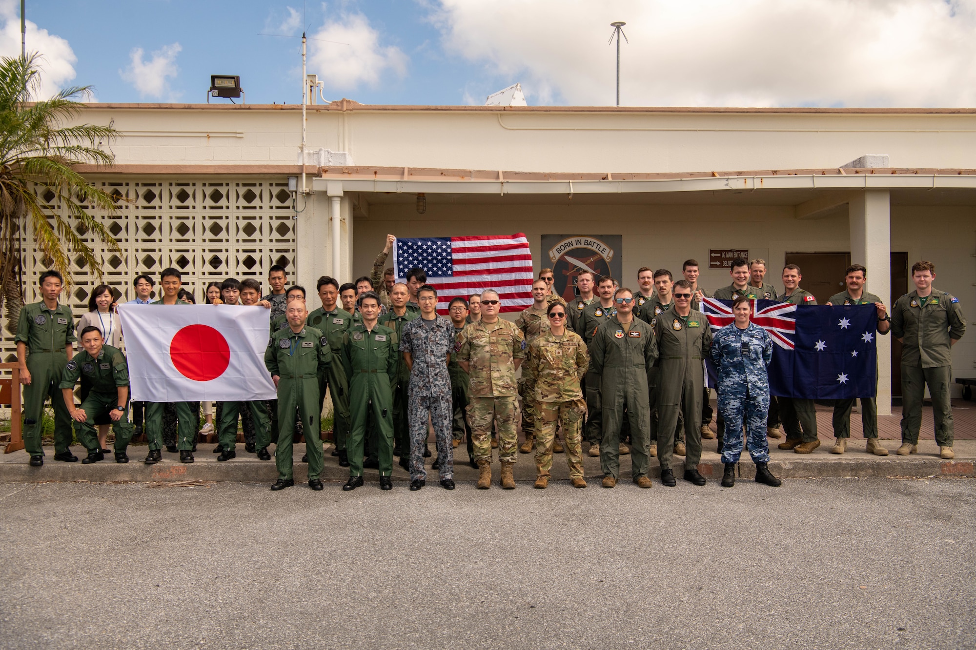 Japanese, Australian, and U.S. military service members pose for a photo.