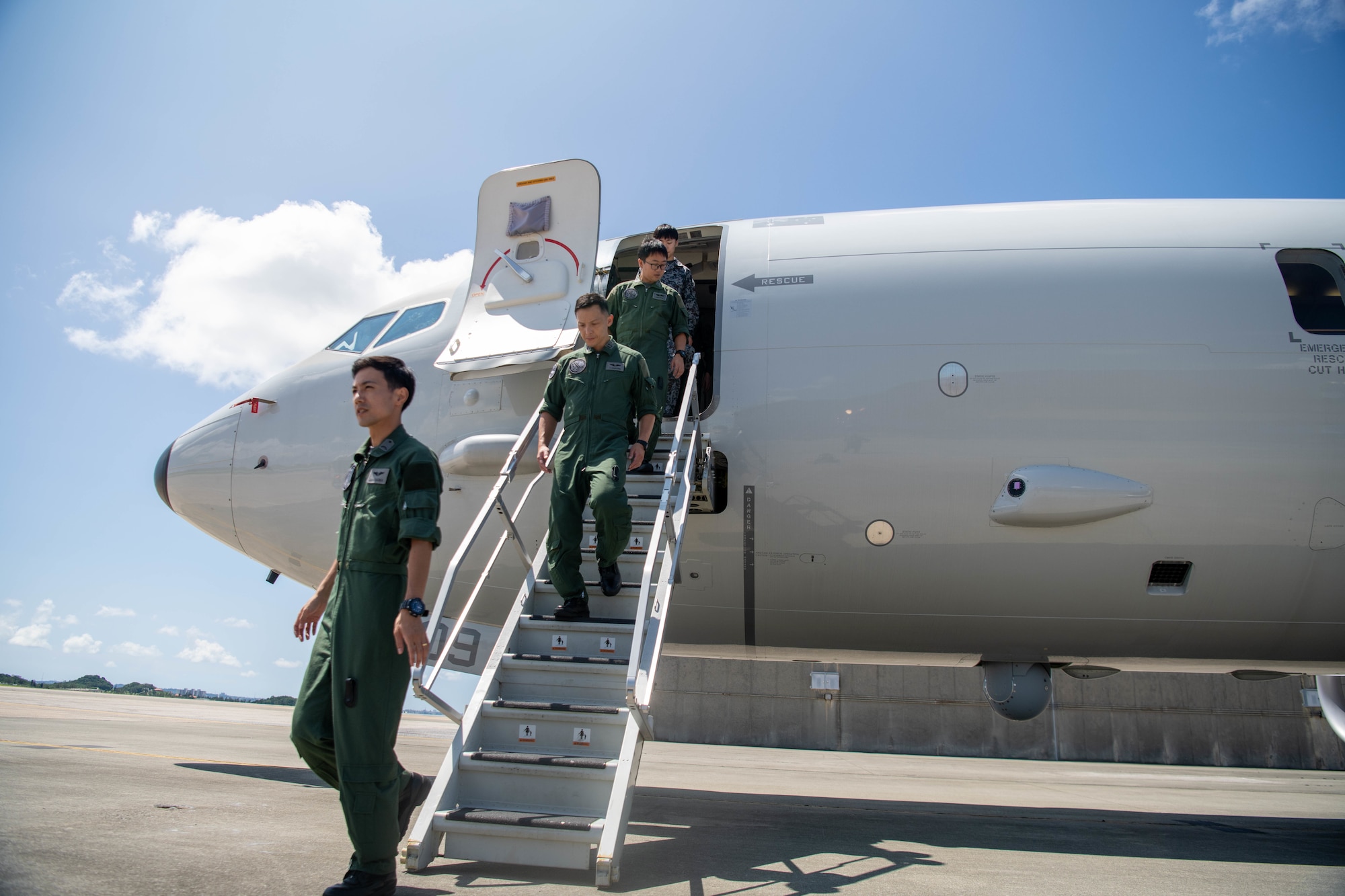 Japanese Service Members disembark an Australian aircraft.