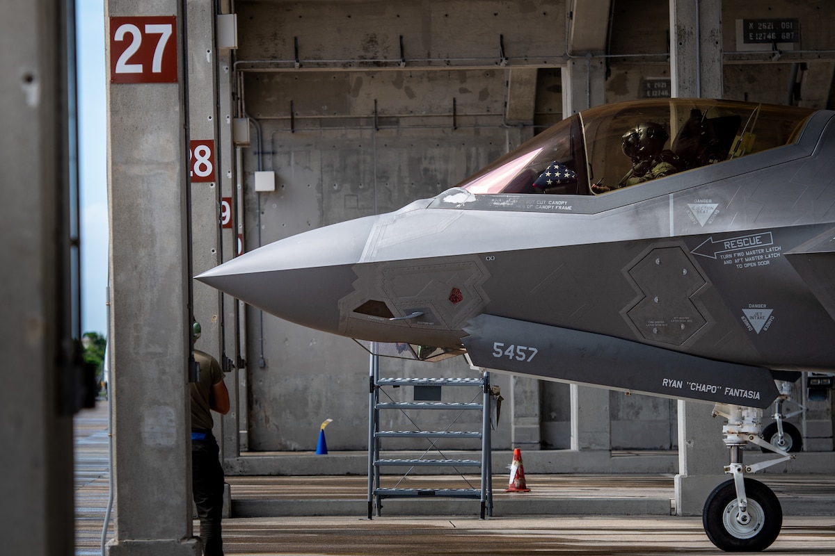 An F-35 Lightning II pokes its nose out of a covered parking spot