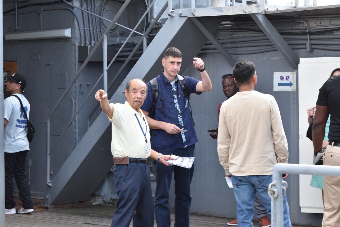 “Greg” Kouta, a Mikasa Preservation Society advisor and retired Japanese Maritime Self-Defense Force captain, makes suggestions about where Major Brad Hull, executive officer of Combined Arms Training Center, Camp Fuji, Japan, and others can begin their tour of the historical Japanese memorial Mikasa warship, September 13, 2023. (U.S. Marine Corps photo by Song Jordan)