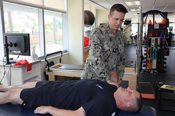 Hospital Corpsman 2nd Class Kevin Wilson, a physical therapy technician assigned to Expeditionary Medical Facility 150 Alpha, provides treatment to Marine Master Sgt. George Spaniel, communications chief for 1st Reconnaissance Battalion, 1st Marine Division, during an appointment at the Naval Hospital Camp Pendleton PT clinic on Sept. 21, 2023.
