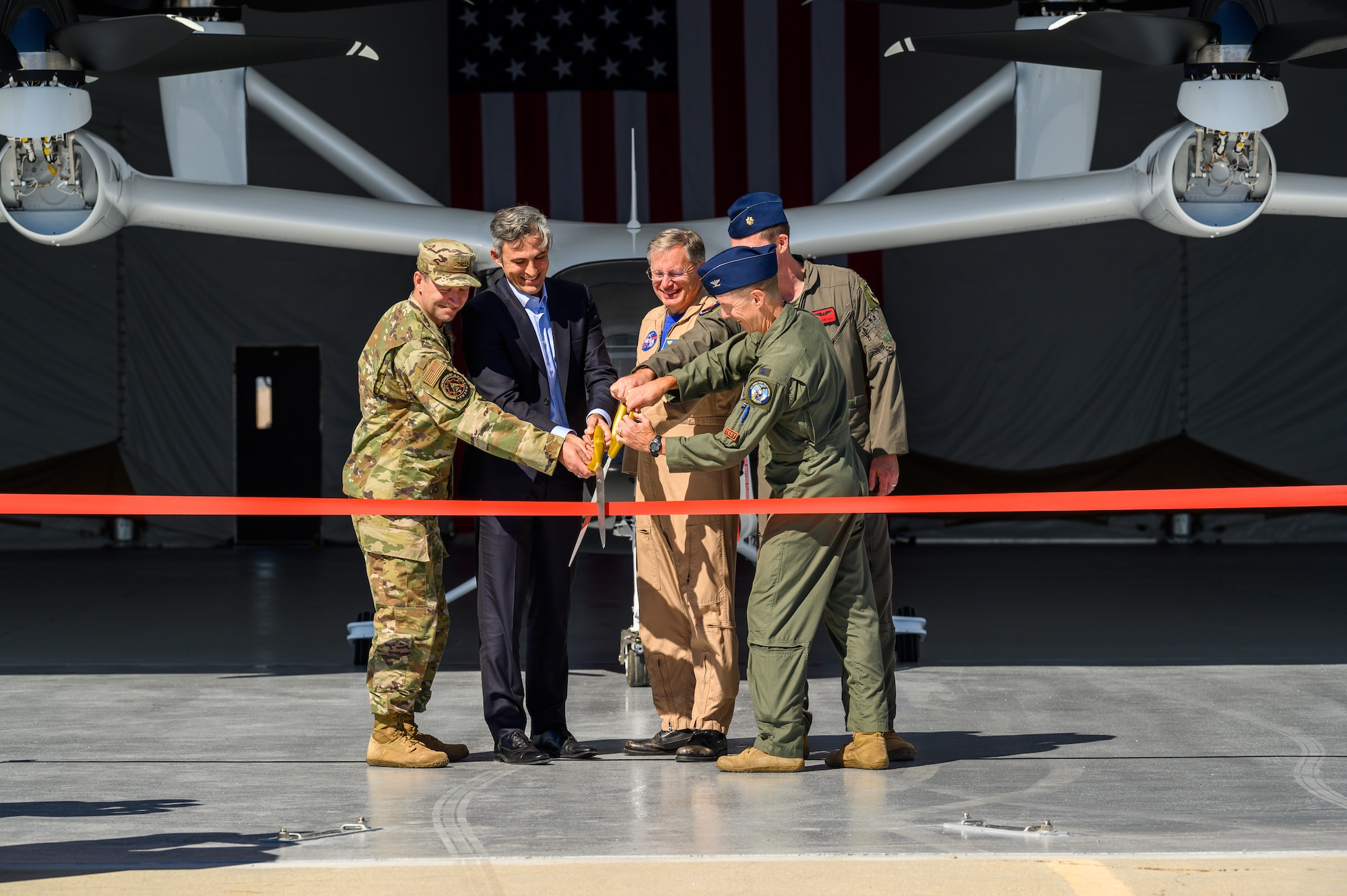 Col. Elliott Leigh, AFWERX director, Paul Sciarra, Joby Aviation, Inc. executive chairman, Wayne Ringleberg, NASA Armstrong Flight Research Center chief pilot, Col. Douglas Wickert, 412th Test Wing commander, and Maj. Phillip Woddhull, Emerging Technologies Integrated Test Force director, cut the ribbon officially opening a large area maintenance shelter for Joby Aviation’s electric vertical take-off and landing test aircraft during a ceremony on Edwards Air Force Base, Sept. 25. (Air Force photo by Richard Gonzales)