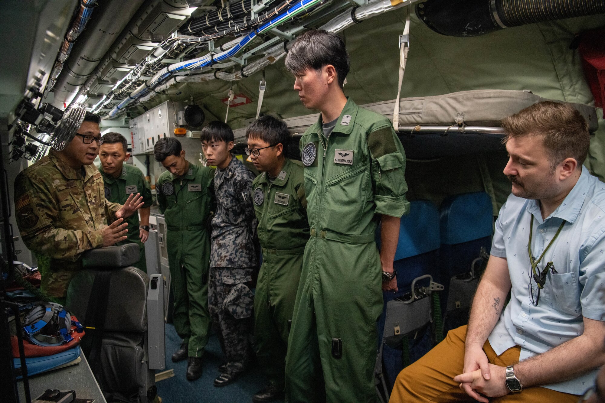An Airman translates RC-135 Rivet Joint Aircraft capabilities to JASDF service members.