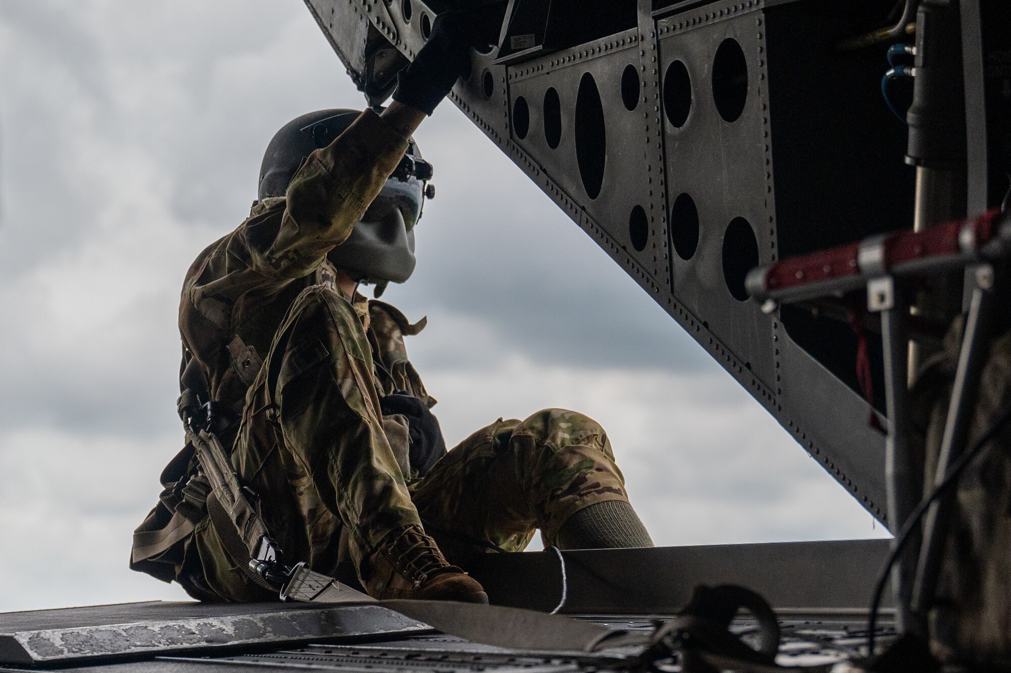 U.S. Army Spc. Joesph Reneau conducts a routine in flight inspection of the U.S. Army CH-47 Chinook while participating in a joint medical evacuation training,